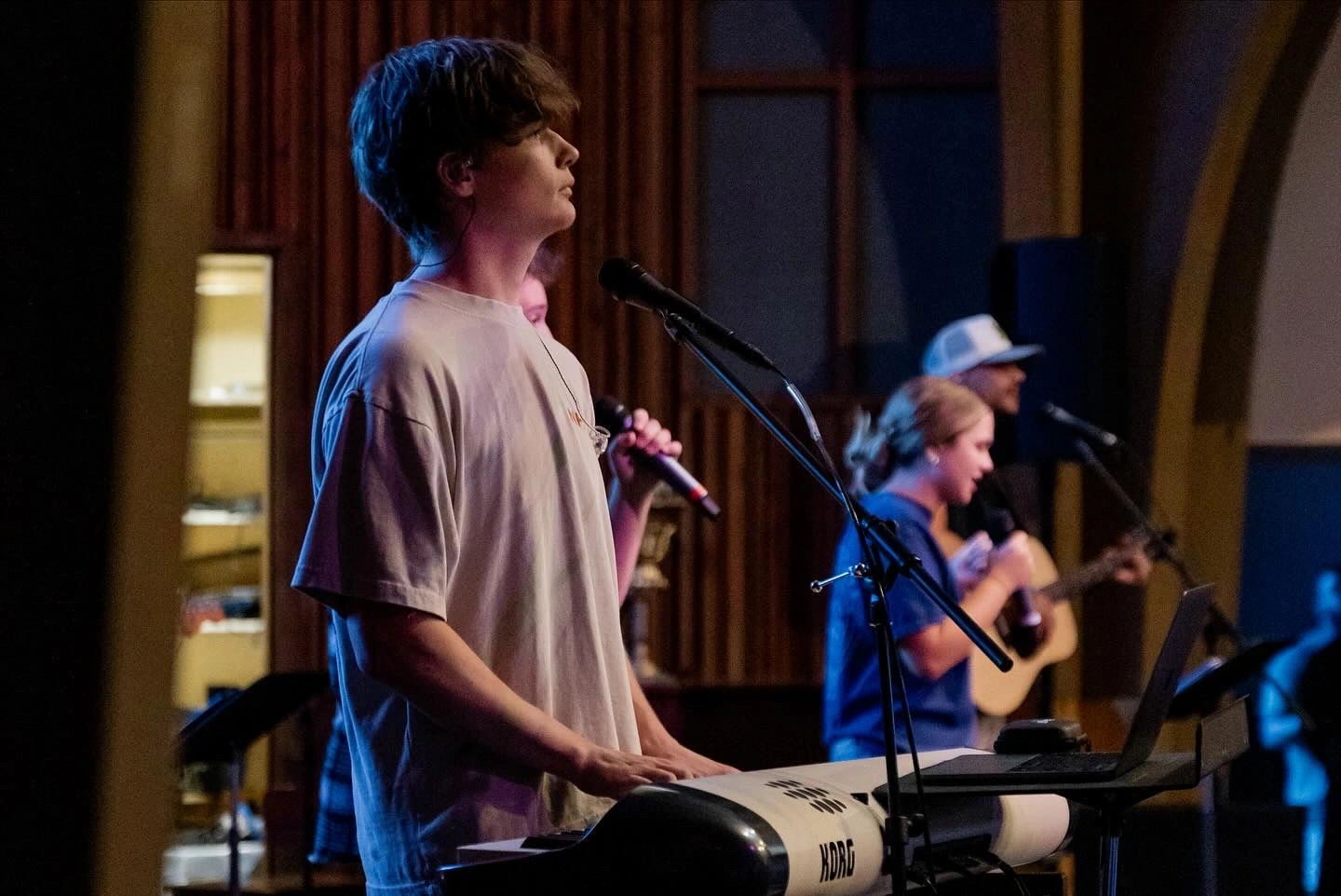 A man playing piano, a band behind him.
